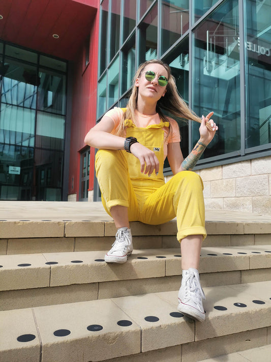 woman wearing YAYS corduroy dungarees, sitting on steps