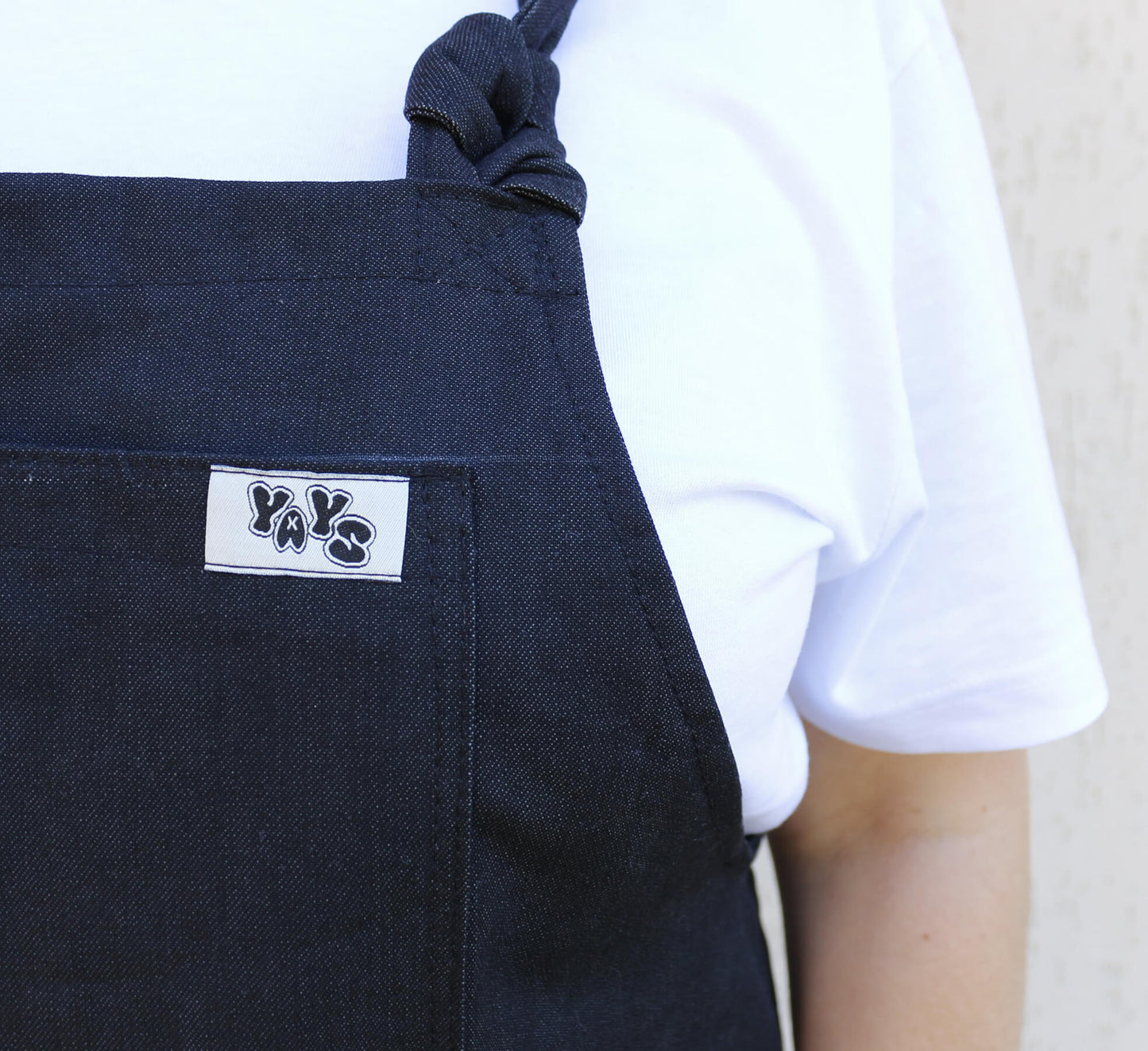 product image of product image of YAYS Unisex Denim Dungaree - Coal Black, close-up on front pochet with YAYS logo