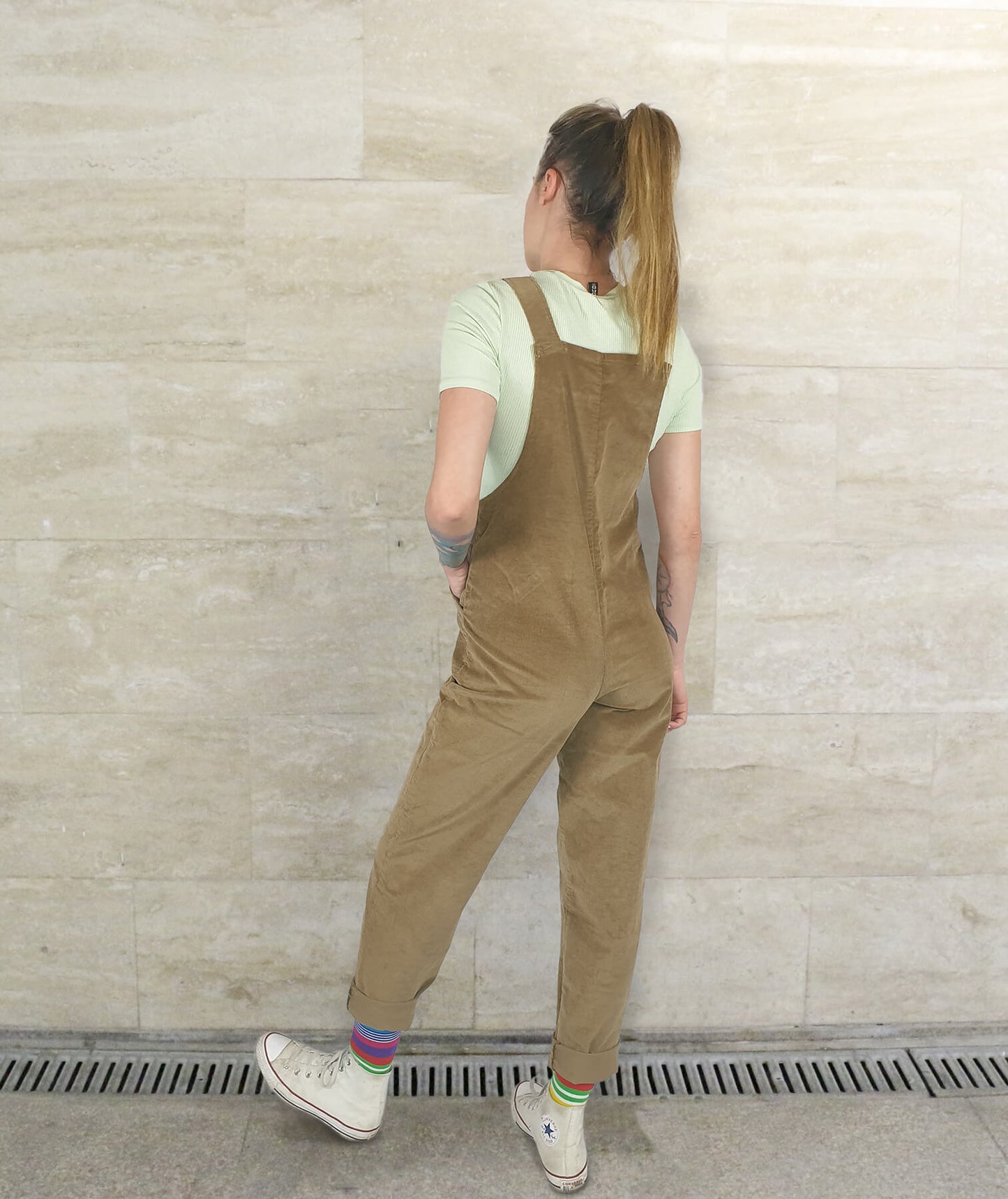 female model posing in YAYS unisex overalls in Cheery Wood, back view