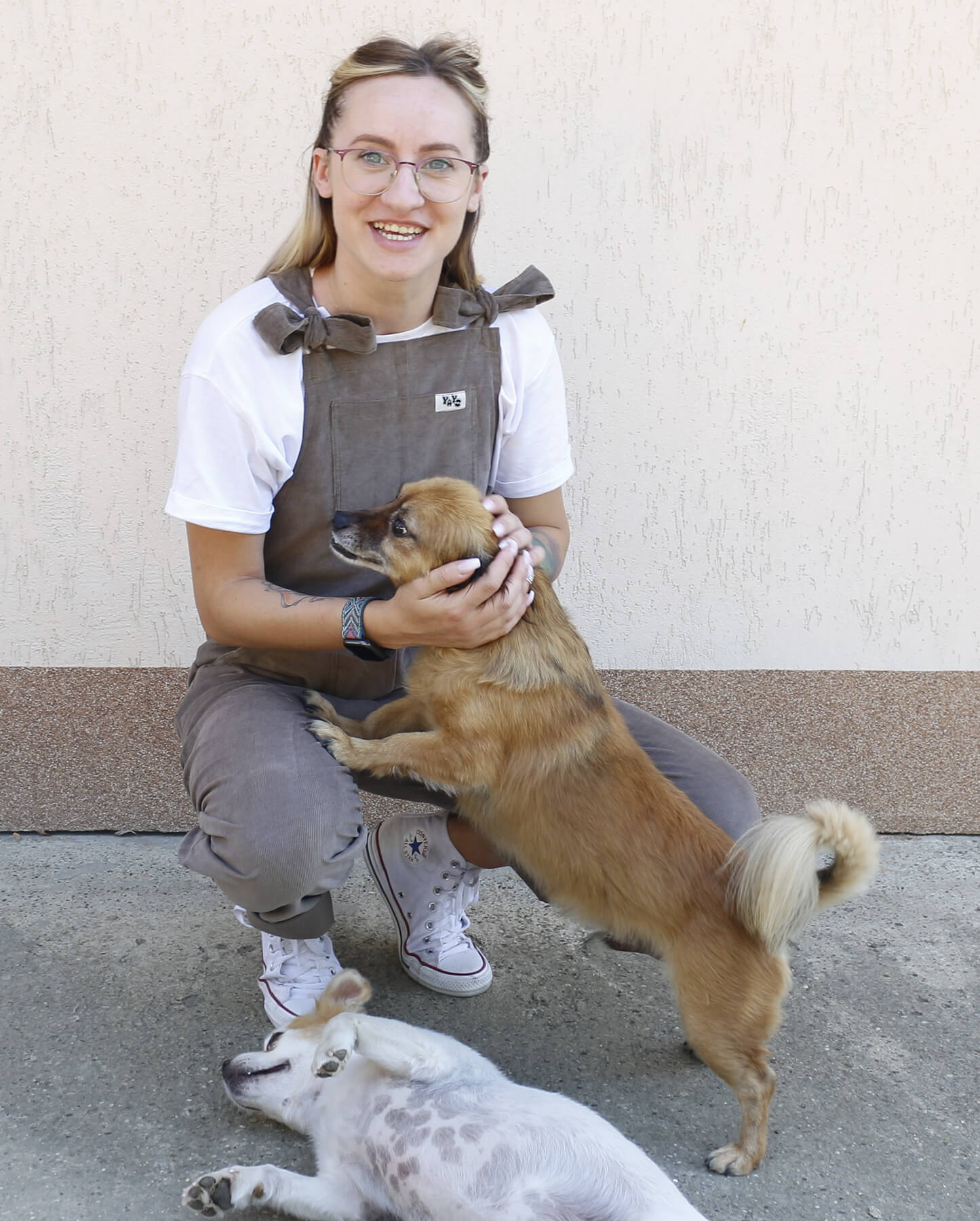 female model posing in YAYS Mink Grey while playing with two small dogs