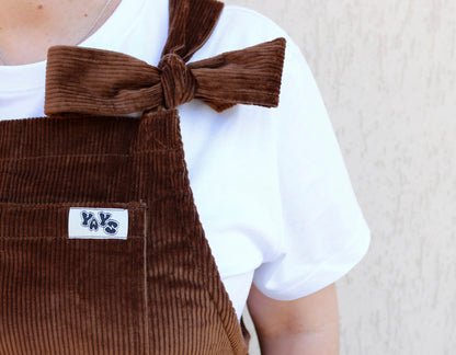 YAYS Pecan Brown dungaree close-up, front pocket, bow strap and logo tag detail showing