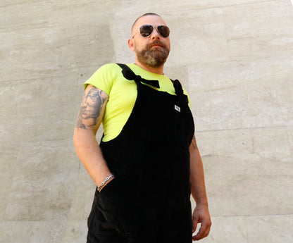 Male model with sunglasses, posing wearing YAYS dungarees in Pine Green, side view