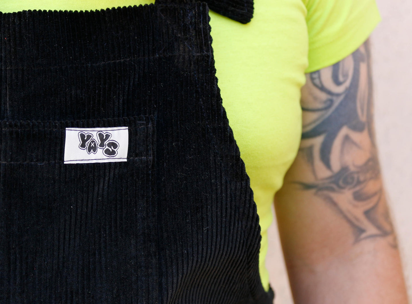 Male model, posing wearing YAYS dungarees in Pine Green, front view close-up on the frotn pocket and YAYS logo tag