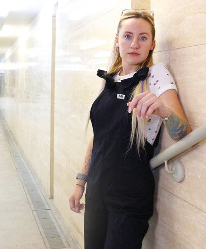 woman wearing YAYS unisex cotton overalls in Raven Black, front view